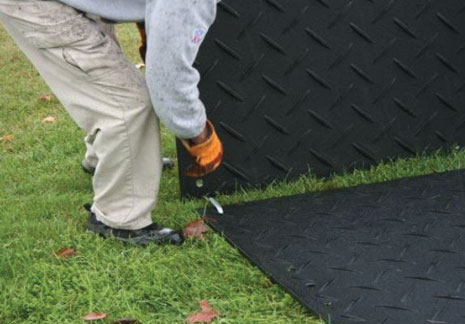 Connector being fitted to a ground protection mat